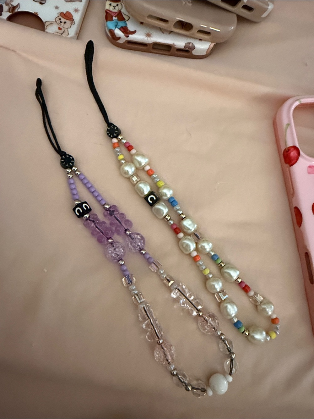 Two Casetify cell phone charm holders with bears, pearls and beads
